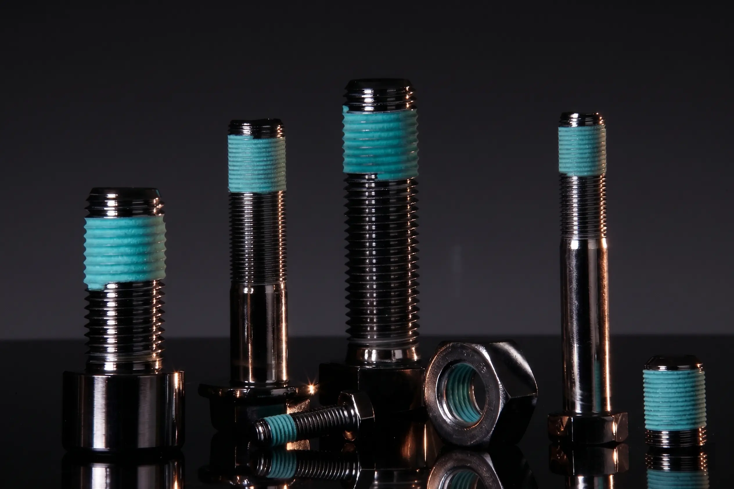 APET Thread Sealing Coating — turquoise dry seal coating on industrial bolt dark